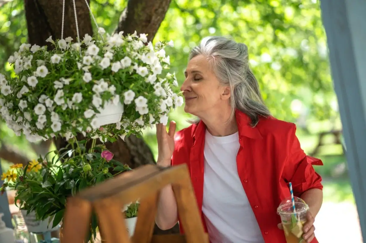 Older woman smelling flowers