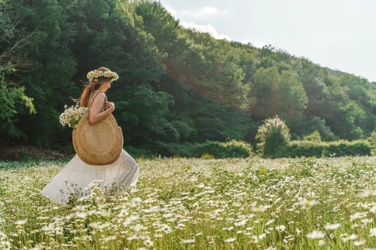 Young woman walking across a flower field