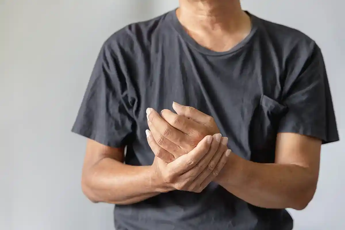 Man in a black t-shirt rubbing his hand