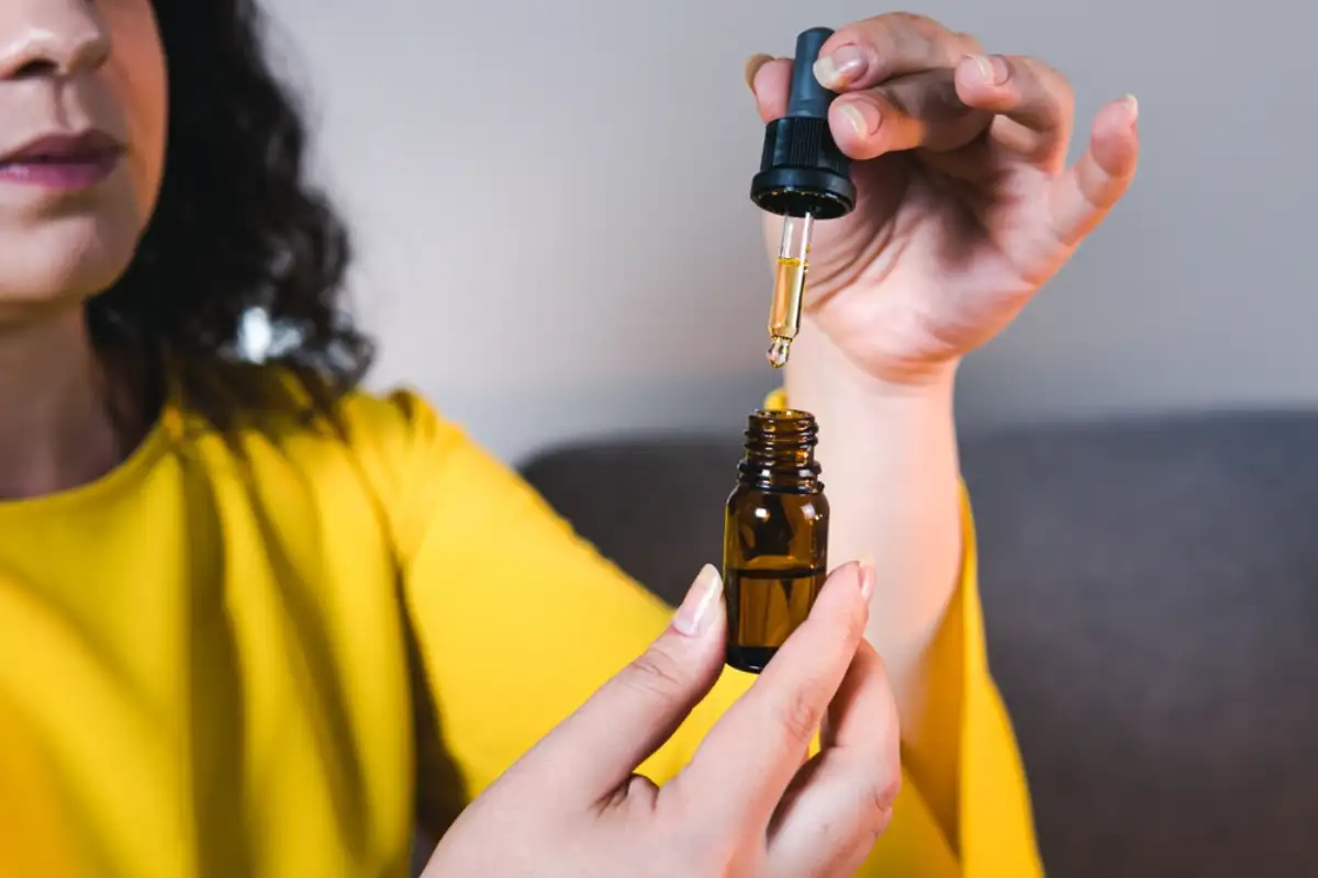 Adult woman using and holding medical cannabis oil
