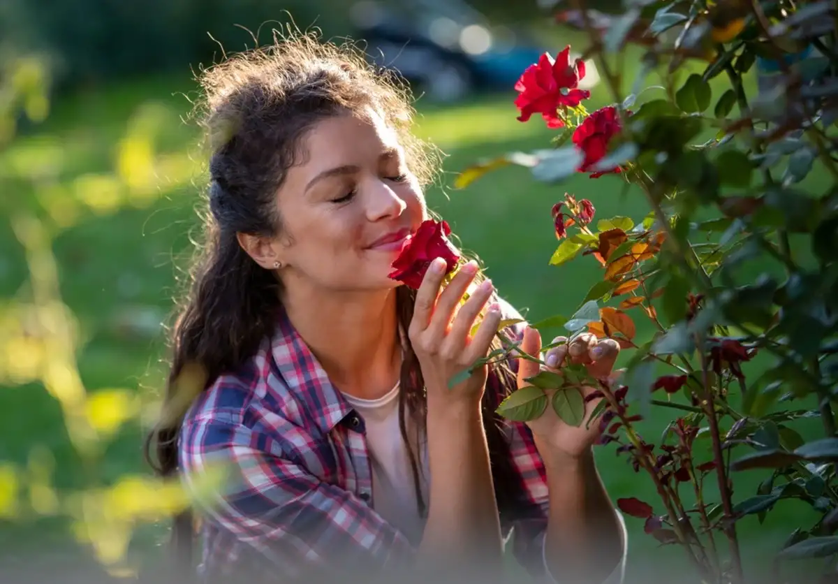 woman smelling flowers in a garden