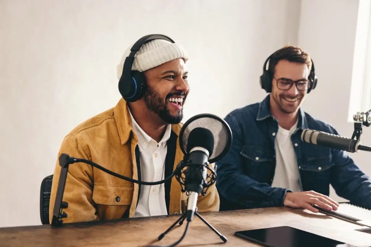 Two men sitting at a table doing podcast