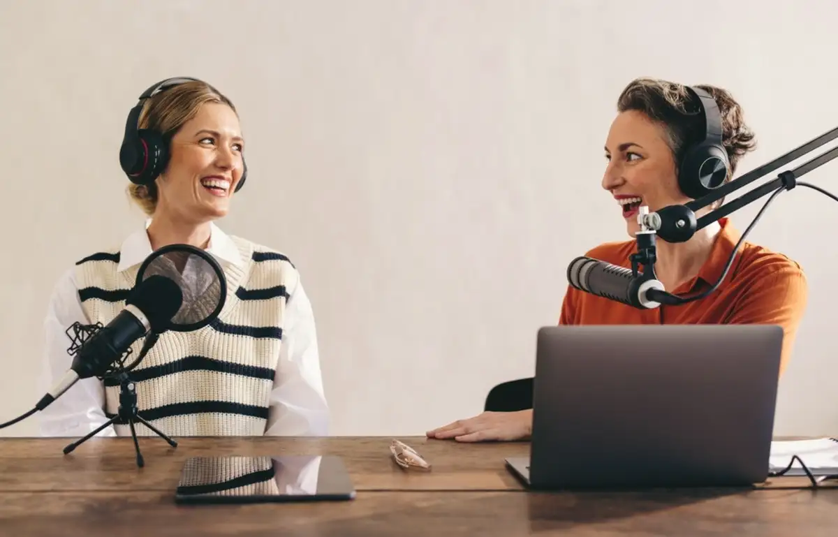 Two women sitting at a table doing podcast