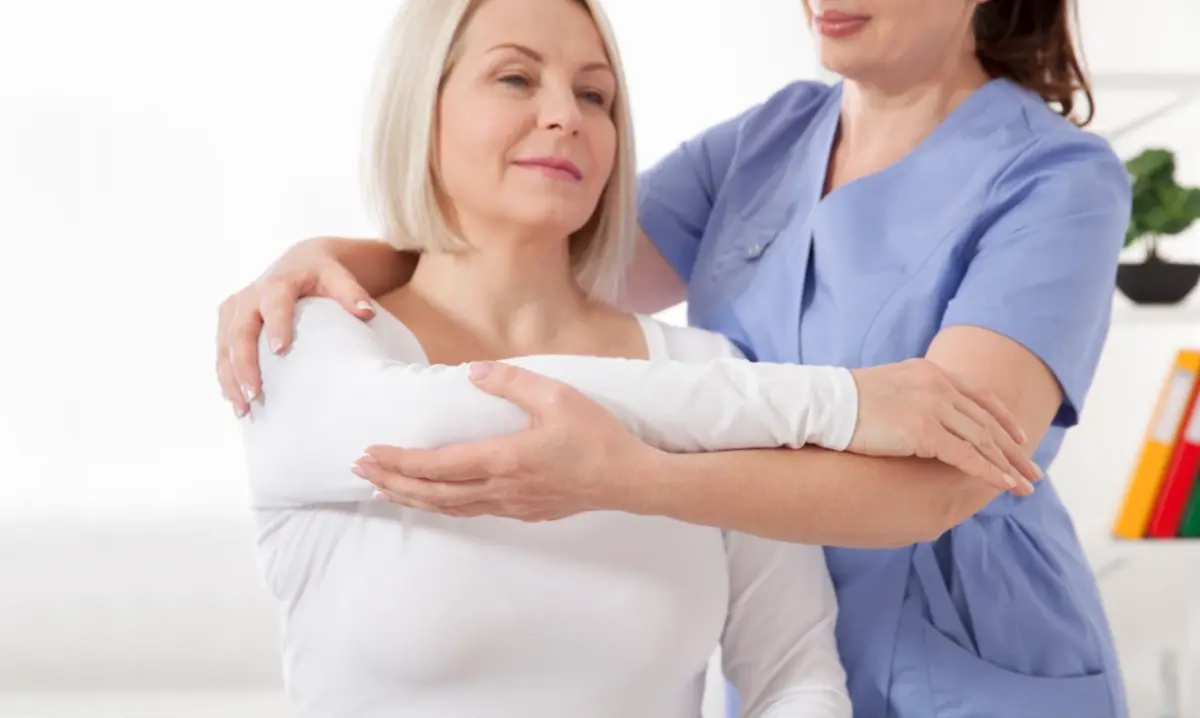 Woman with a cast on her arm is being assisted by a nurse