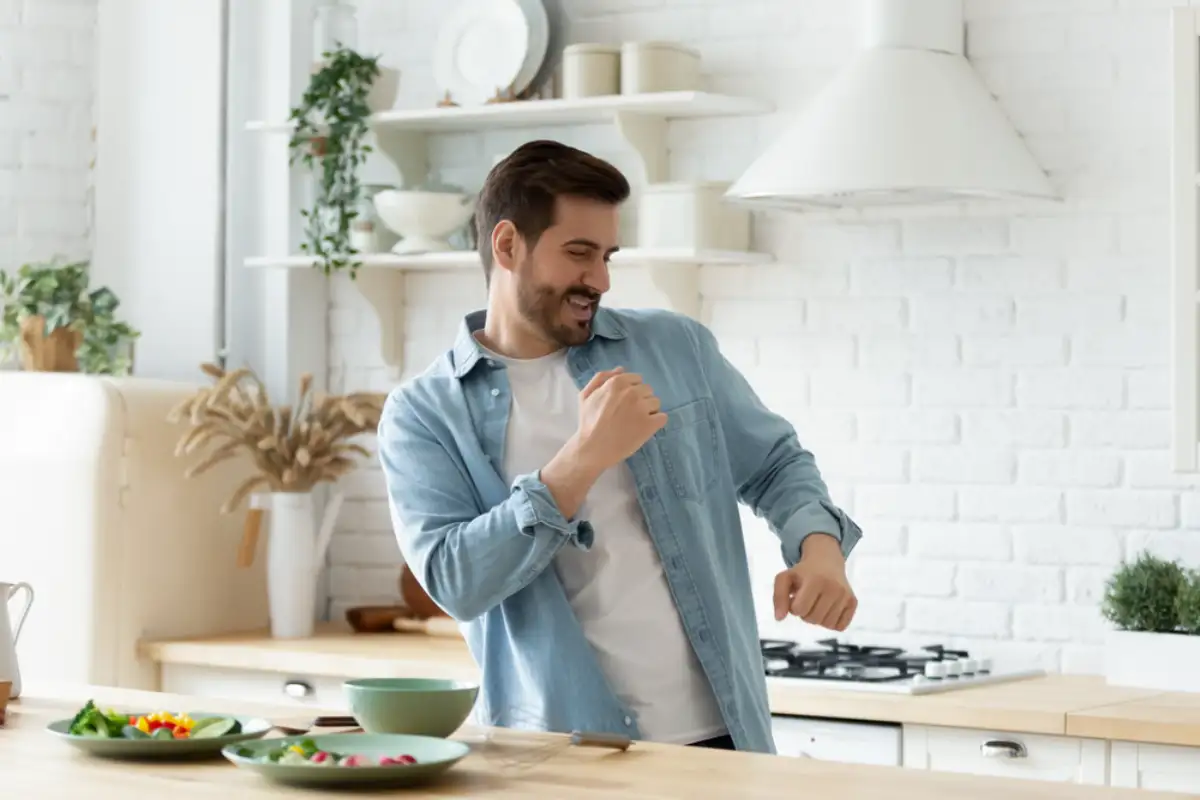 Energetic man dancing at the kitchen