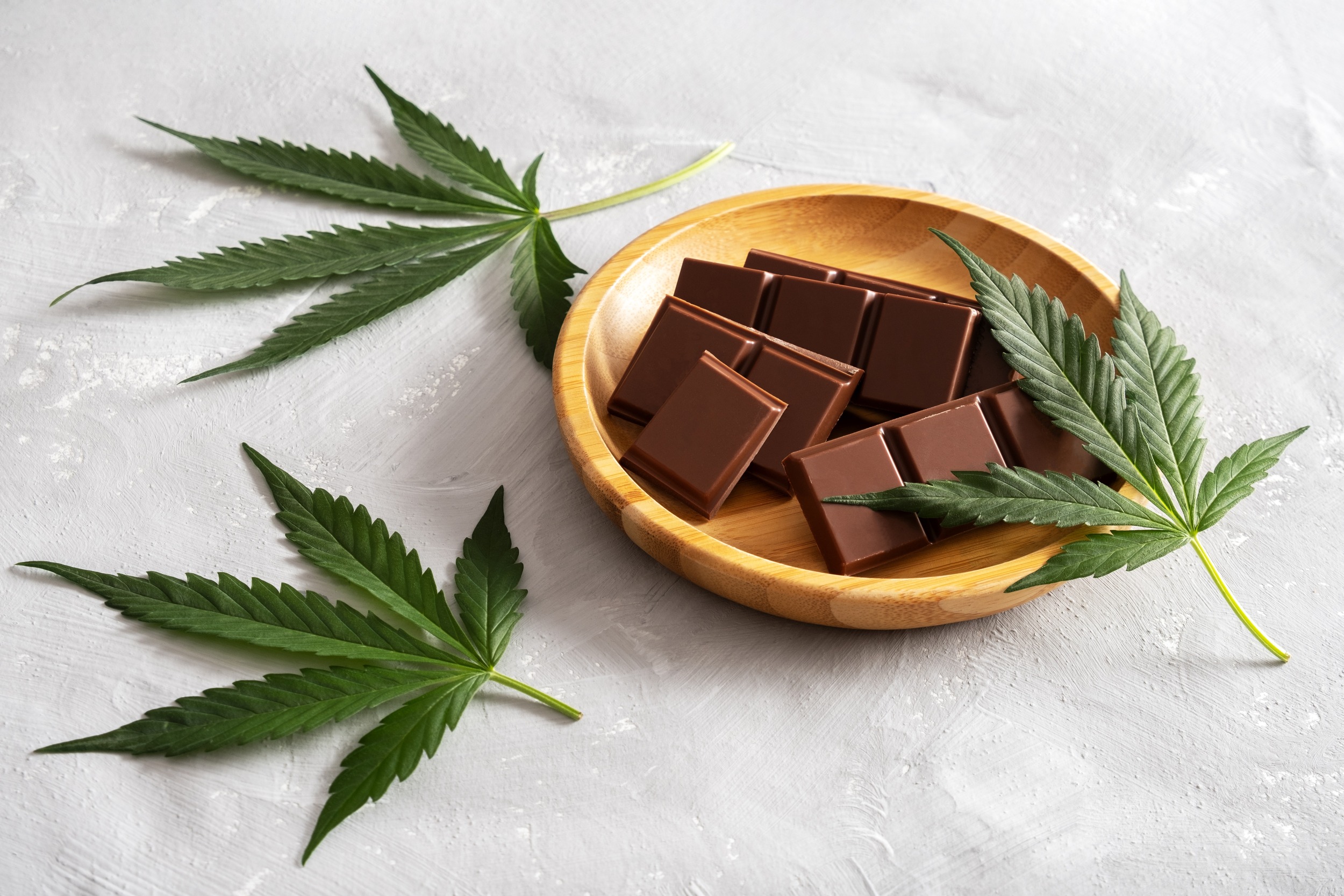 chocolate-bars-on-wooden-tray-with-cannabis-leaves