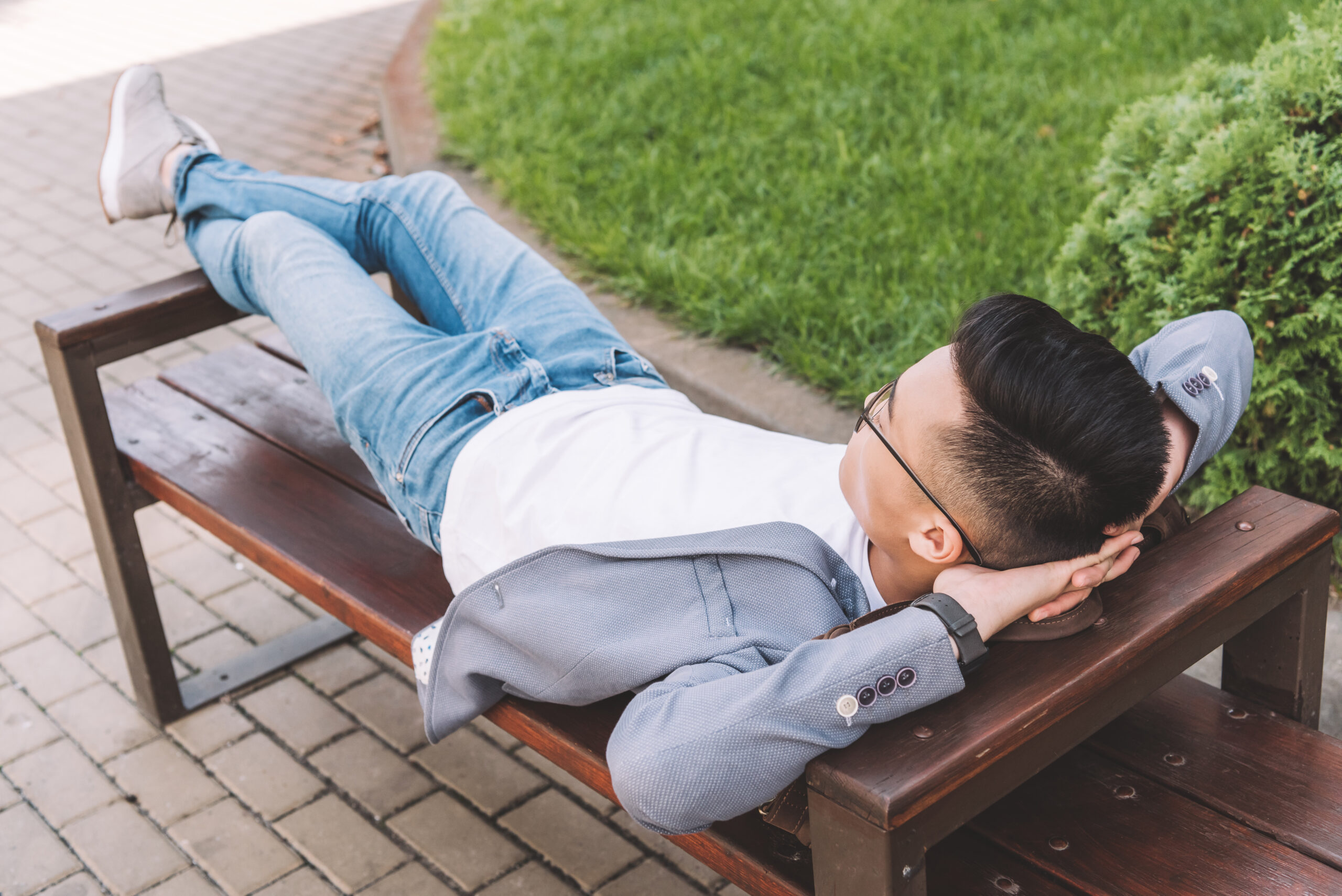 stylish man in gray jacket resting on bench