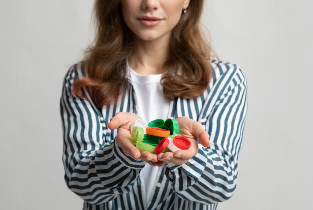 unrecognizable-lady-holding-colorful-plastic-lids