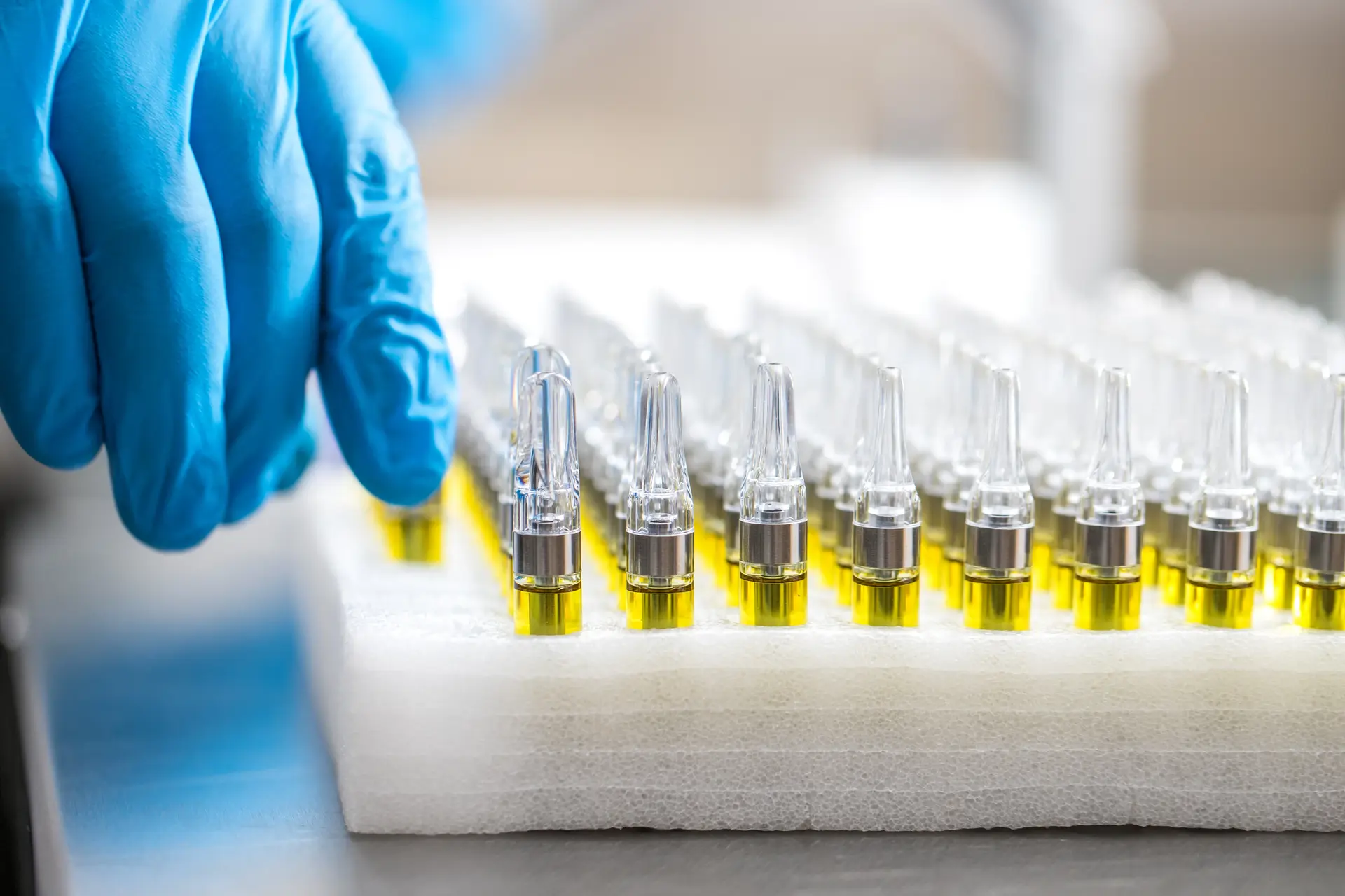 Cannabis vape cartridges production line with technician.