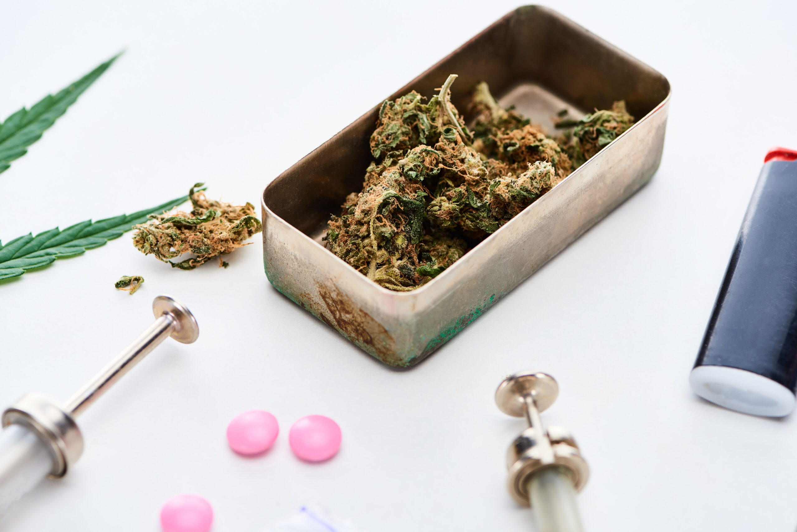 close-up-view-of-marijuana-buds-syringes-and-ligh