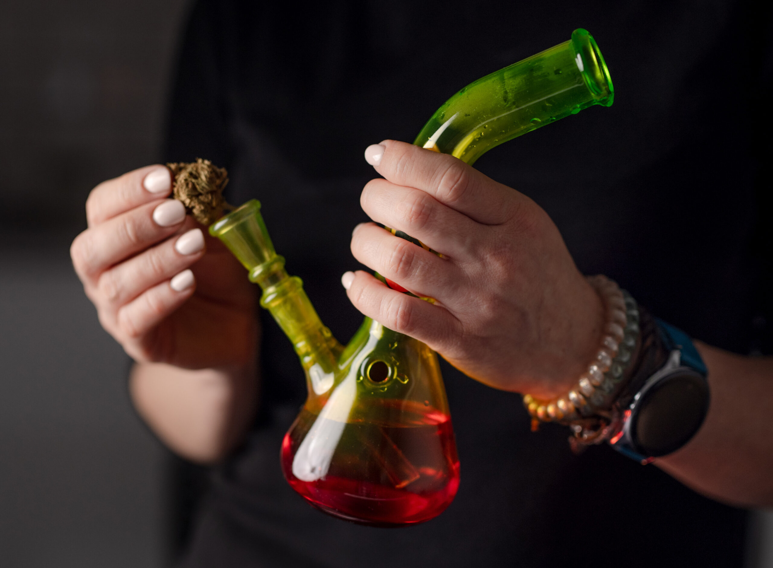 woman-fills-bong-with-cannabis-leaves